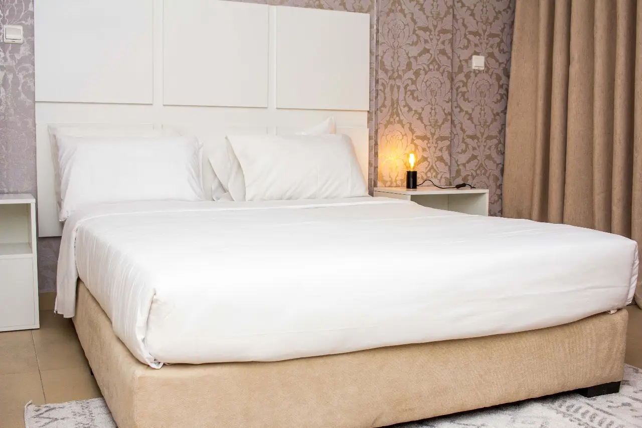 Close up photo of bedroom at Doritis Guest House, a boutique hotel, featuring a comfortable bed with a white frame.